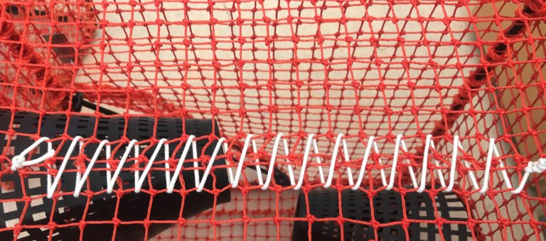 Figur 3: Døme på rømmingshol der snittet i notlina er lissa saman med bomullstråd. Foto: Landmark Skaar / Fiskeridirektoratet