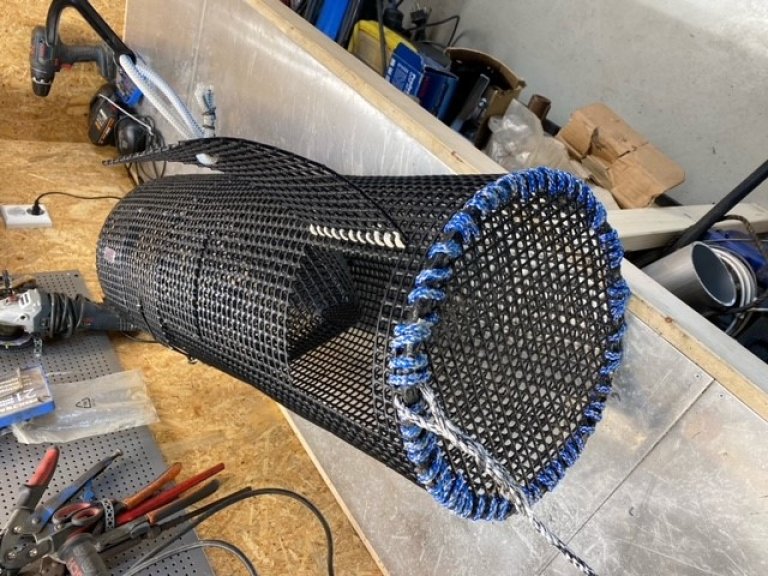 Figur 5: Bomullstråd montert i innfestinga til tømmeluka. Bomullstråden skal berre knytast i endane. Foto: Landmark Skaar / Fiskeridirektoratet